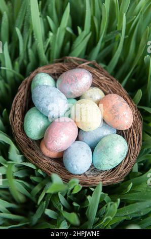 Colorful easter eggs in nest on green fresh grass Stock Photo