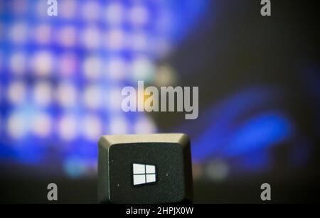 Windows start key picked up from the keyboard and placed in front of a window Stock Photo