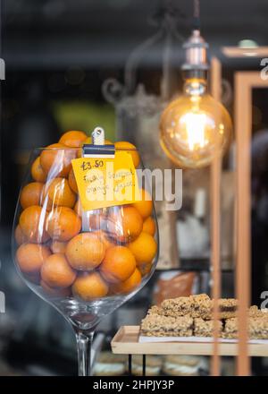 Freshly squeezed orange juice in shop window advertising tasty fruit drink to customers.  Homemade bright coloured citrus fruit juice. Stock Photo