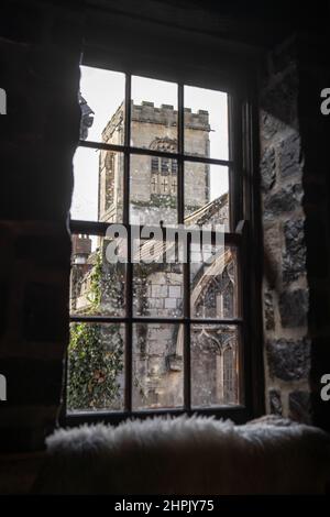 Old medieval churched viewed through pane glass window on rainy day in ancient English city. Stock Photo