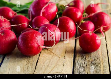 A lot of red radishes on a  brown wooden table Stock Photo