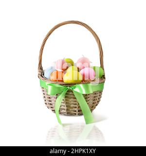 Easter wicker basket with pastel colorful eggs isolated on white background. Festive Christianity religion tradition. Stock Photo
