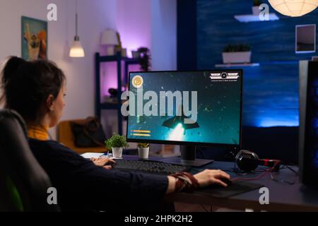 Adult using keyboard and mousepad to play video games on computer. Gamer  playing online game in