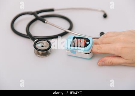 Stethoscope, pulse oximeter and thermometer gun on white background. Phonendoscope. Infrared isometric thermometer gun to check body temperature for Stock Photo