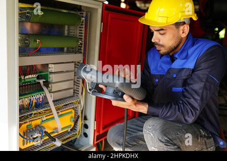 engineer checking control panel and teaching new Automatics robot arm and operating control machine in factory. Stock Photo