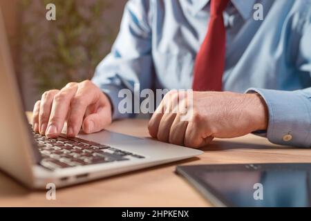 Close up of male hands using laptop, businessman working on portable computer, selective focus Stock Photo