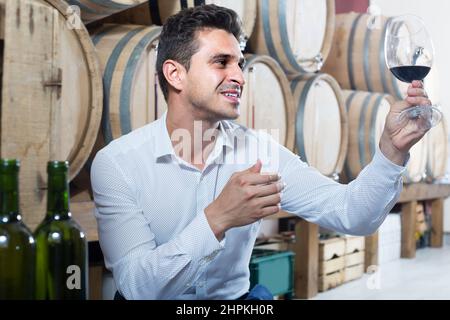 man tasting wine in cellar Stock Photo