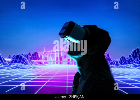 Female person using Virtual reality headset in metaverse universe. Experiencing virtual reality internet metaverse Stock Photo