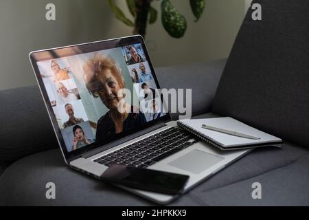 Laptop screen with multi-person conference, collage of group of multiracial people, webcam view, video chat. A lot of different headshots on computer Stock Photo