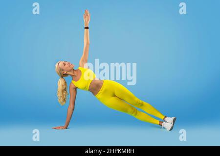 Smiling Young Woman Doing Side Plank Balance Exercise Stock Photo