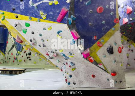 Colored climbing wall for training at modern bouldering gym Stock Photo