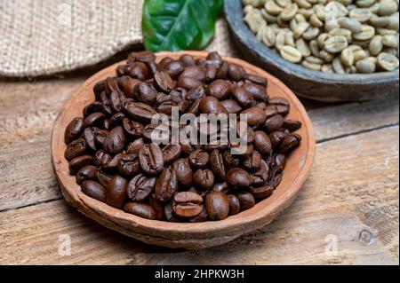 Green un-roasted and brown roasted coffee beans from Africa coffee producing region, cultivating in Ethiopia, Ivory Coast, Uganda, Kenya, Rwanda and T Stock Photo