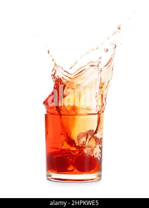 Glass of tasty Manhattan cocktail with splashes isolated on white background Stock Photo