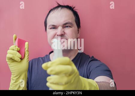 Angry man janitor in yellow gloves, studio isolated on a white ...