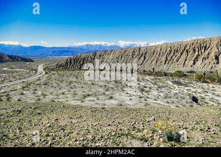 Road through barren desert between Coachella and Thousand Palms Oasis in Coachella Valley Preserve, Mojave Desert, California, USA. Stock Photo