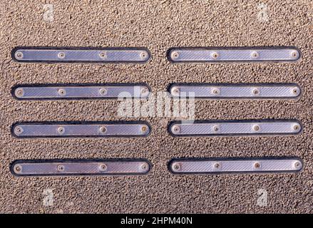 Close up of metallic cat eyes or pavement guidance marker for disabled reflectors textures pattern on asphalt. High quality photo Stock Photo