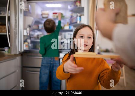 Little chidlren helping mother in kitchen at home. Stock Photo