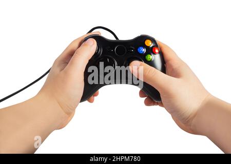 Isolated photo of first person view male hands holding black colored and wired modern game pad controller on white background. Stock Photo