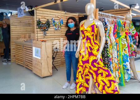 Young woman with face mask in a clothing kiosk seen in in the traditional fair in the Cinema Reserva Cultural Niterói. The event showcases culturally Stock Photo