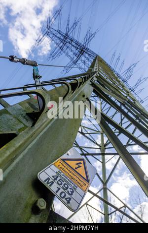 High voltage danger to life, warning sign on an overhead power line pylon Stock Photo