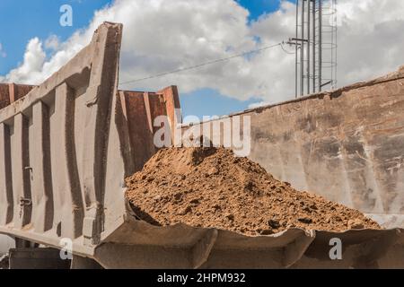 Dump truck with a pile of sand in the back construction washed earthworks on site. Stock Photo