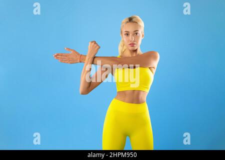 Portrait of confident young slim woman stretching her arms Stock Photo