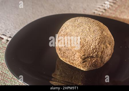 Handmade bread on a black dish with tablecloth in the background and copy space. Stock Photo
