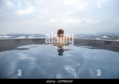 Woman bathing in hot tub at mountains Stock Photo