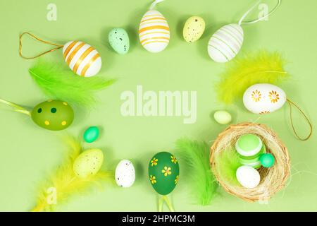 Happy easter. Delicate, pastel salad background with a nest, colorful eggs and feathers. View from above. Place for text. Stock Photo