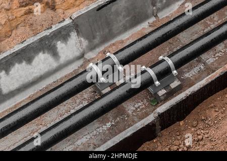 Repair of the water line of the heating main pipe in the ground trench pipeline at the construction site work industry. Stock Photo