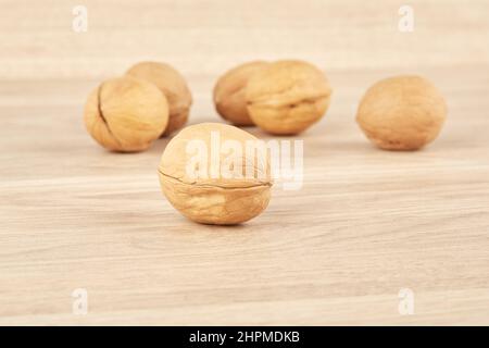 Walnuts lie in the center on a wooden background Stock Photo