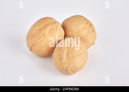 Three walnuts lie side by side on a white background Stock Photo