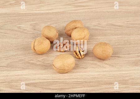 Whole walnuts on a wooden background together with peeled walnuts Stock Photo