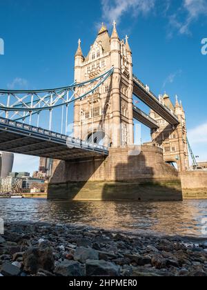 Tower Bridge, London. A low, wide angle view of the popular landmark crossing the River Thames at low tide. Stock Photo