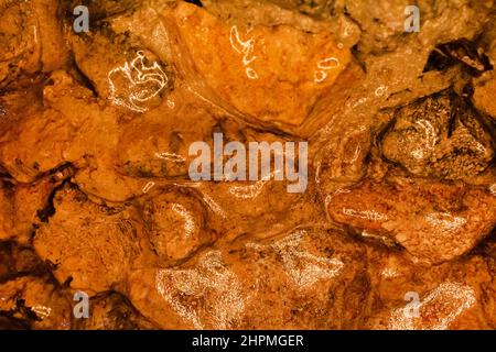 Photo of orange toned frozen stone gravel wall surface covered in ice texture. Stock Photo