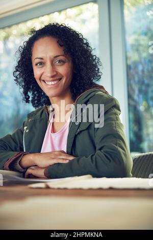Ill be taking my weekend out on the patio. Portrait of a relaxed mature woman sitting at a table outside on the patio. Stock Photo