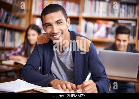 Hes such a diligent student. Cropped portrait of a handsome young student working diligently in his classroom. Stock Photo