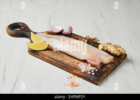 Freshly frozen zander fillet on wooden cutting board Stock Photo