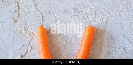 easter bunny carrot ears on light textured background. Stock Photo