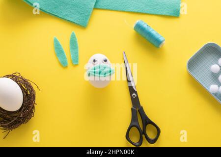 How to make felt bunny for Easter decor and fun.  DIY concept. Step by step photo instruction. Step 12. Cut out the rabbit ears from felt. Stock Photo