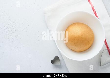 Baking ingredients and kitchen utensils on a white background top view. Preparing heart sugar cookies. Baking background. Flour, eggs, sugar, spices, Stock Photo