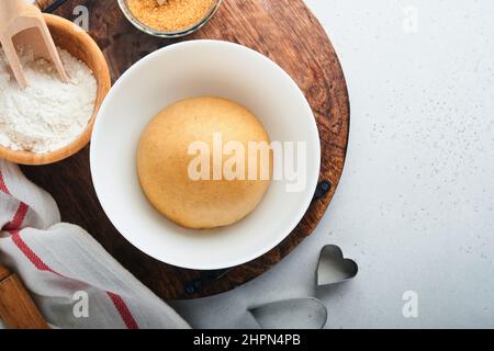Baking ingredients and kitchen utensils on a white background top view. Preparing heart sugar cookies. Baking background. Flour, eggs, sugar, spices Stock Photo