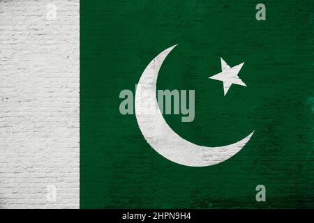 Full frame photo of a weathered flag of Pakistan painted on a plastered brick wall. Stock Photo