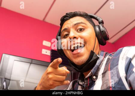 Latino man working in an office pointing at the camera with his index finger Stock Photo