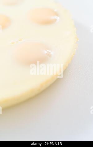 Cutting hard-boiled eggs in a shape of a loaf on a white cutting board. Stock Photo