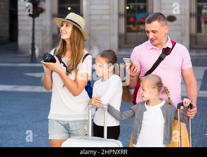 parents with two kids using smartphone and photographing sights during their travel Stock Photo