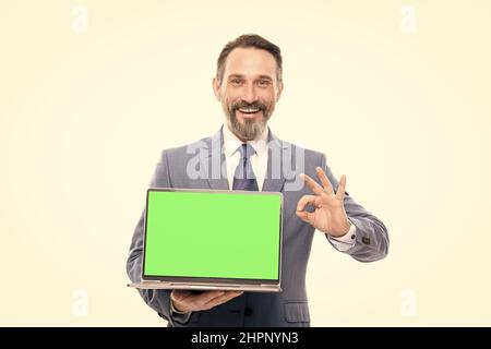 office manager ready for video conference. happy grizzled man showing laptop screen. Stock Photo