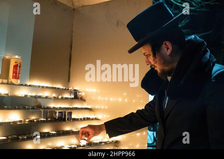 Lezajsk, Poland. 21st Feb, 2022. An ultra orthodox Jew (hassid) is seen lighting a candle. Every year ultra orthodox Jews come to Lezajsk (Poland) to visit the grave of Tzadik Elimelech to pray, dance and sing during his death anniversary. This is the traditional ceremony of Hassid Jews. They visit also the Jewish cemetery in Lancut, where Tzadiks Horowitz and Szapiro have graves. (Photo by Wojciech Grabowski/SOPA Images/Sipa USA) Credit: Sipa USA/Alamy Live News Stock Photo