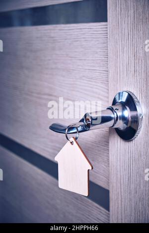 Key with keychain in form house in door lock Stock Photo