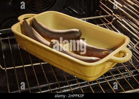 Baked bananas in ceramic bowl in the oven. French gourmet cuisine Stock Photo